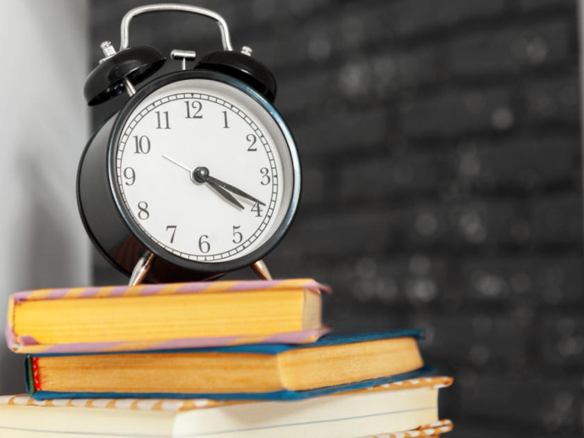 alarm clock on top of homeschool books, representing homeschool schedule