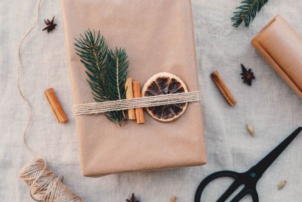 Minimalist gift wrapping with natual decorations - fir branches, cinnamon sticks