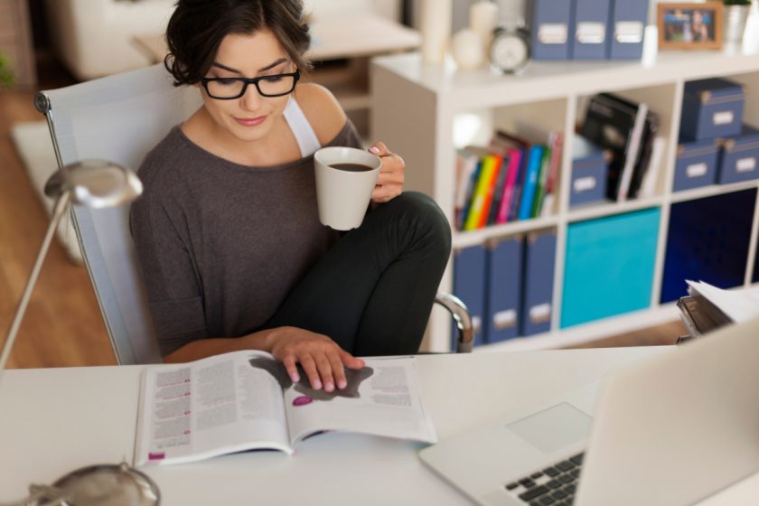 homeschool mom reading at desk, deciding what clean house means to her