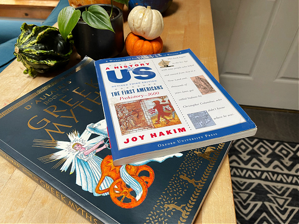 d'aulaires book of greek myths and a history of US book 1 on table with plants and pumpkins