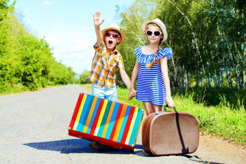 kids dressed up as tourists standing on side of road pretending to hitch hike