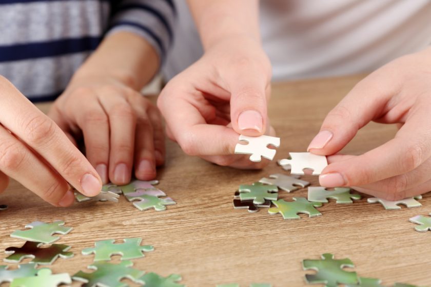 parent and child doing christmas jigsaw puzzle