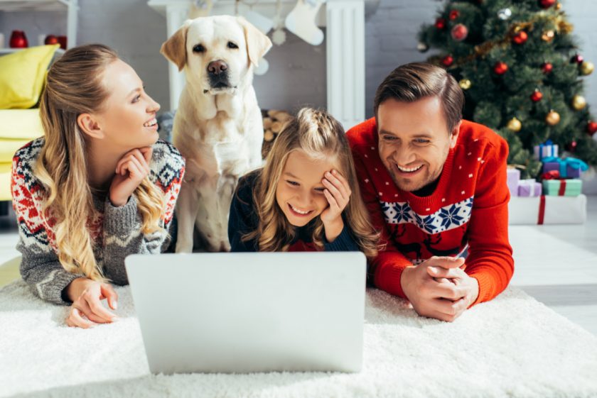 family watching movie on laptop lying on the floor on christmas day