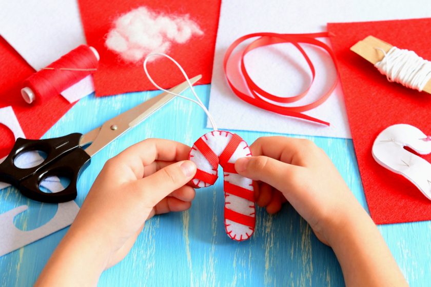 little hands making felt candy cane christmas ornaments