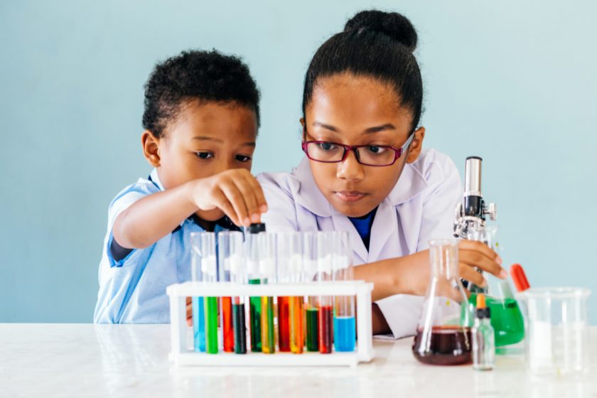 young boy and older sister using test tubes for color-changing science experiment