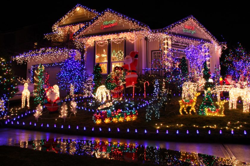 house decorated with hundreds or christmas lights and lawn ornaments