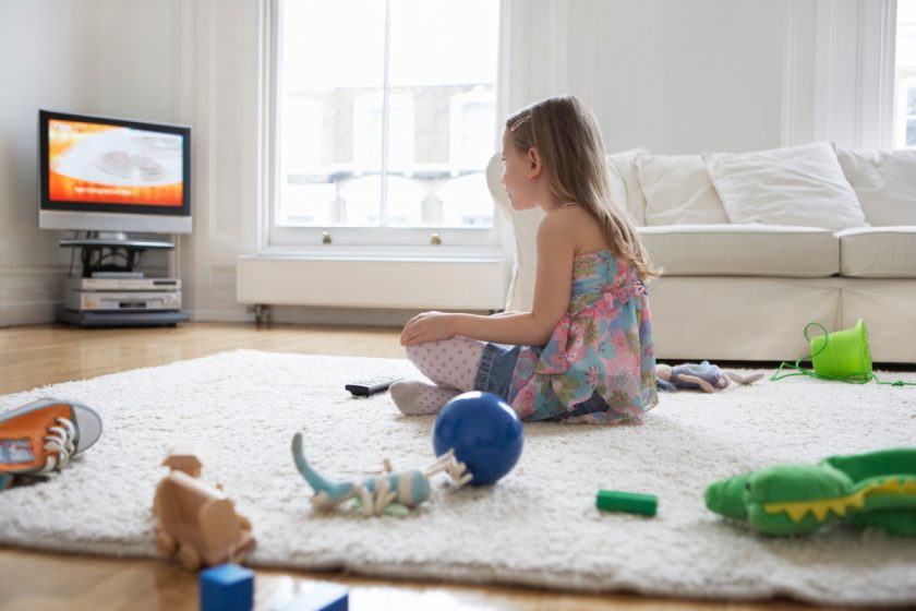 girl sitting on floor watching t.v.