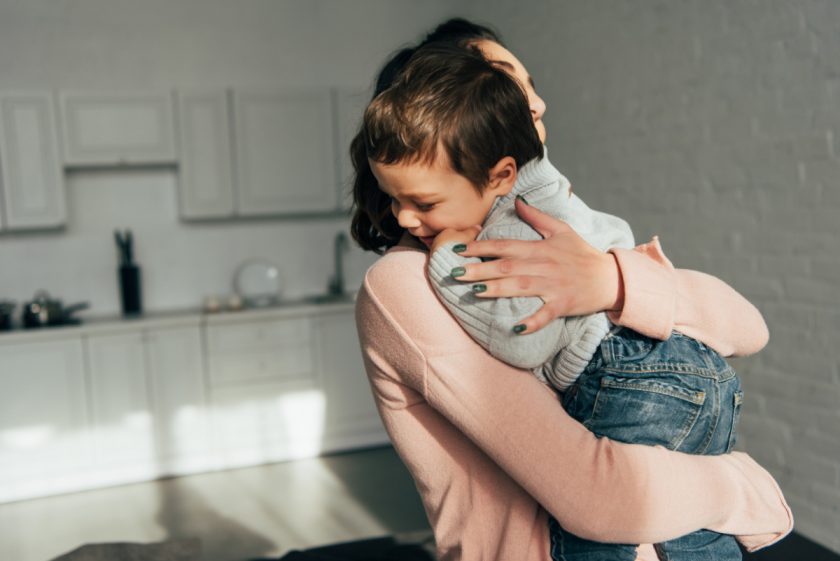 mom hugging toddler boy in kitchen