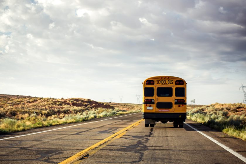 school bus driving away on open road