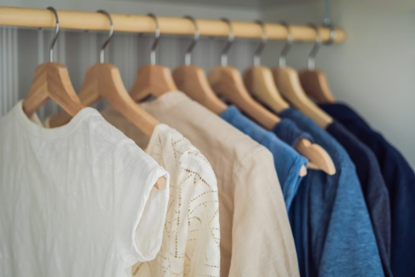 White and blue clothes on hangers in closet