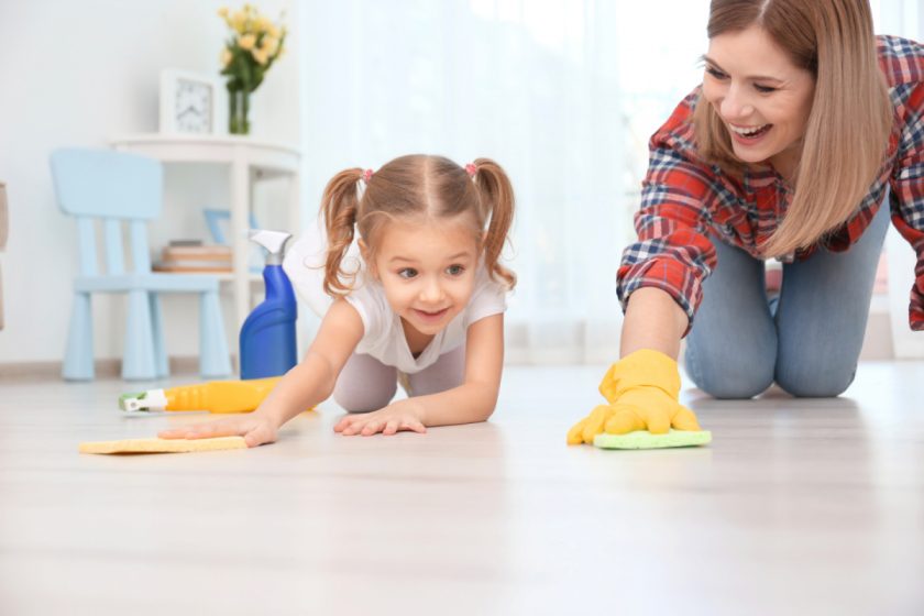 Little girl and homeschool mom cleaning floor at home