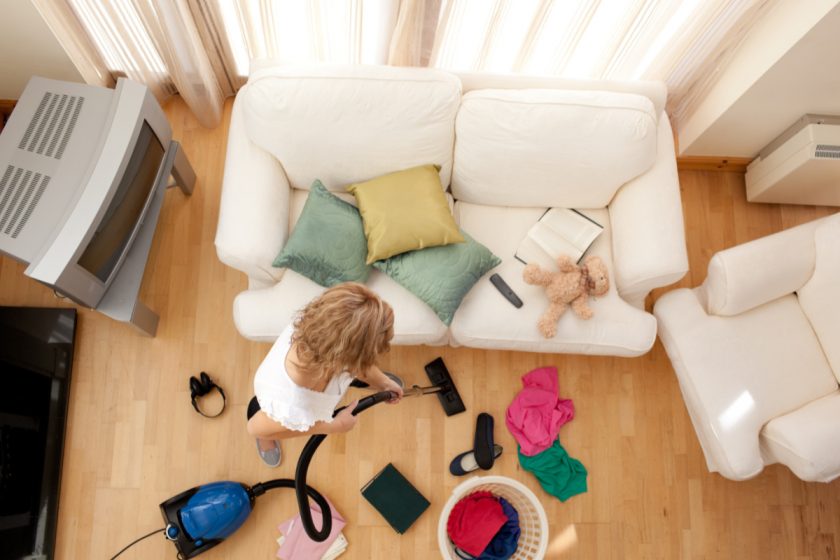 homeschool mom vacuuming messy living room, following cleaning schedule