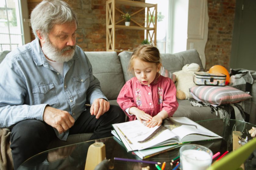 child reading with grandfather
