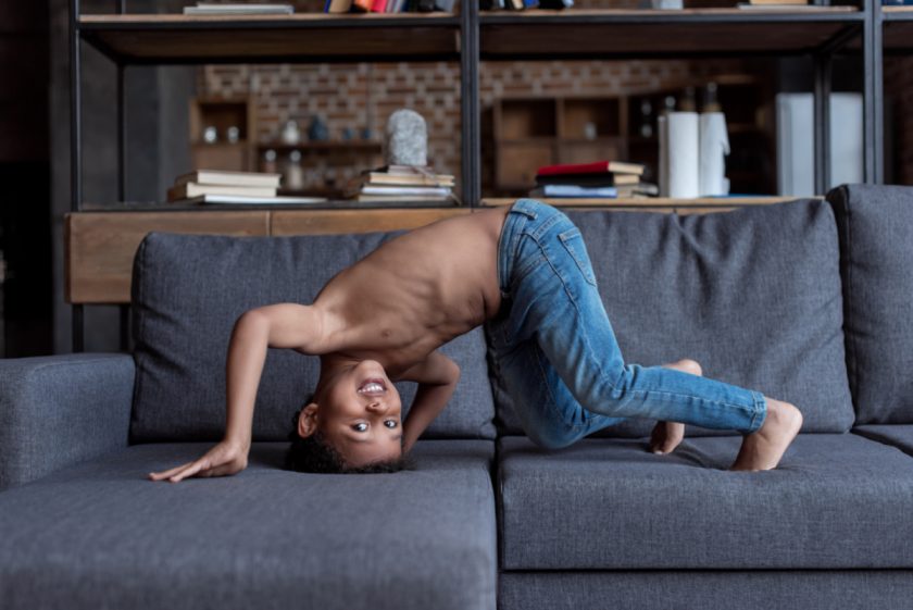 boy with head upside down on couch, almost tumbling