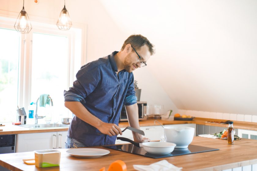 minimalist dad cooking dinner in bright spacious kitchen