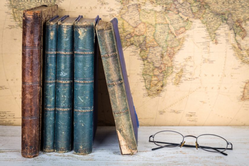 history concept - old books, map and reading glasses