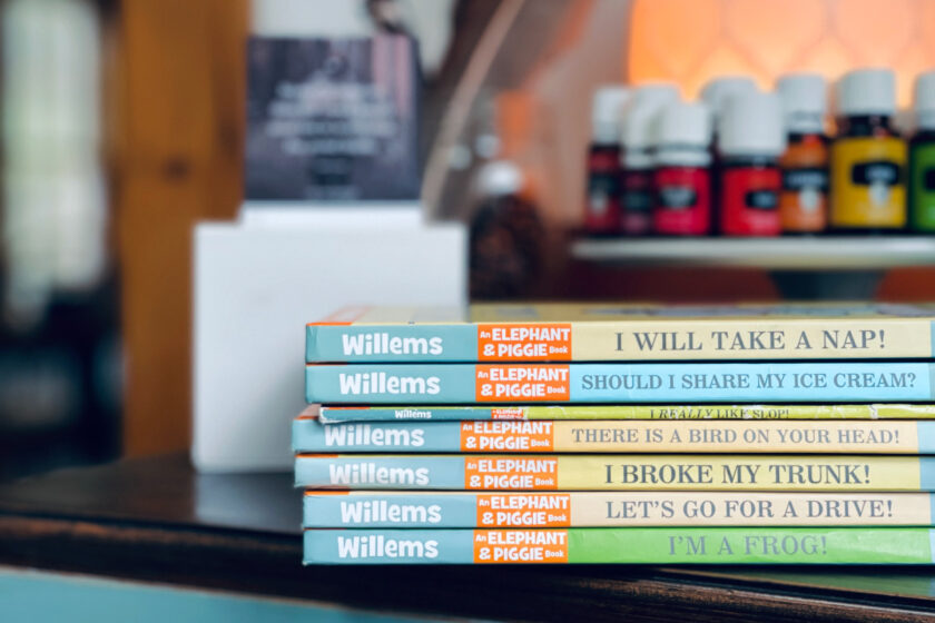 stack of elephant and piggie books sitting on table near essential oils and quote display