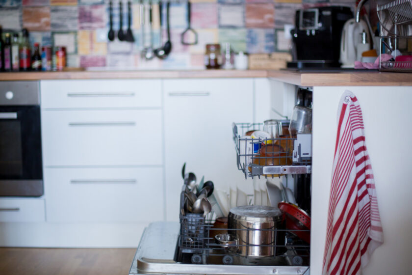 Dishwasher, filled with dirty dishes and glasses in a modern kitchen