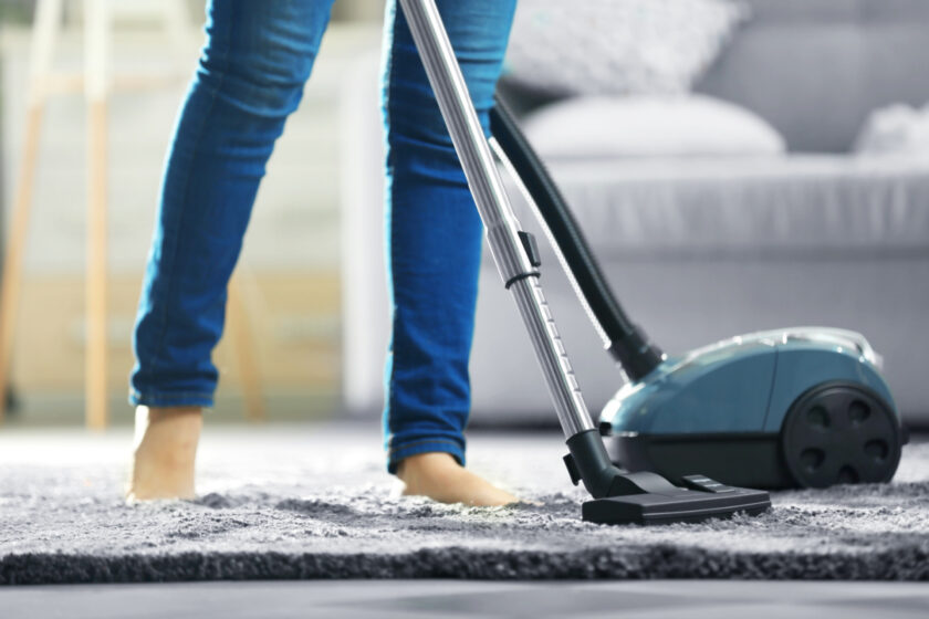 minimalist cleaning the carpet with vacuum cleaner in the living room