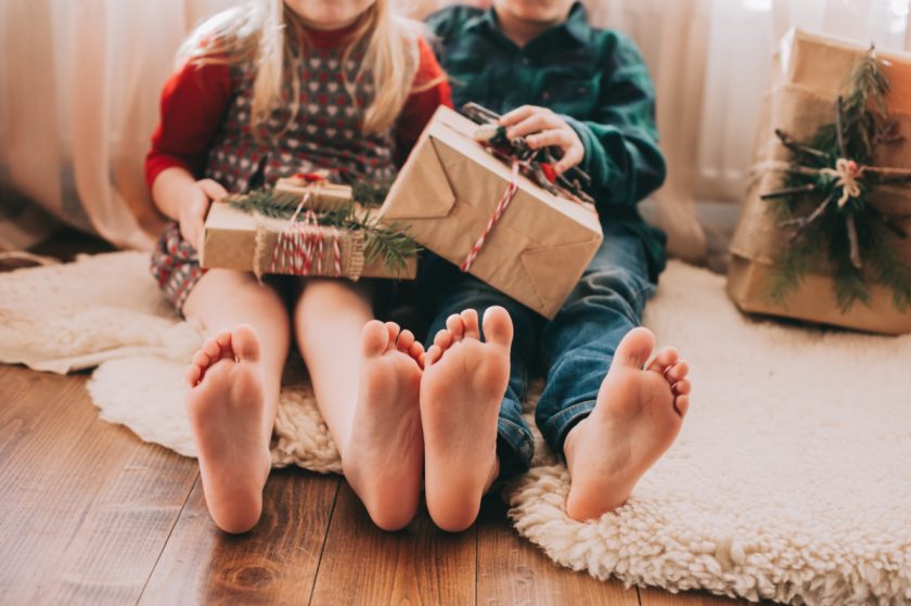 two kids sitting side by side with small gifts on their laps