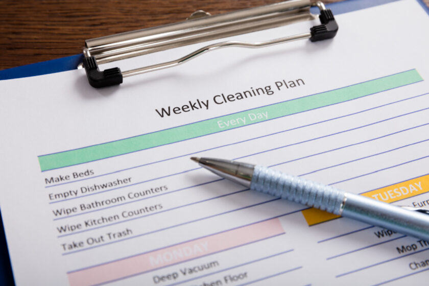 cleaning schedule on clipboard, with every day tasks and weekly tasks 