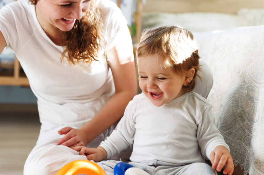 smiling mom enjoying life without goals by playing with her happy toddler