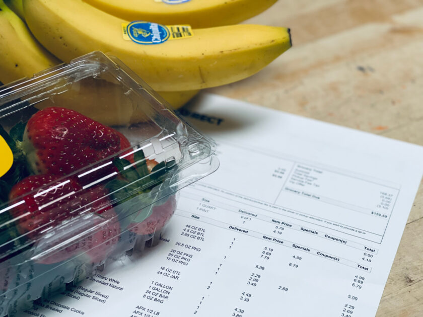 bananas and strawberries on top of grocery receipt, frugal living theme