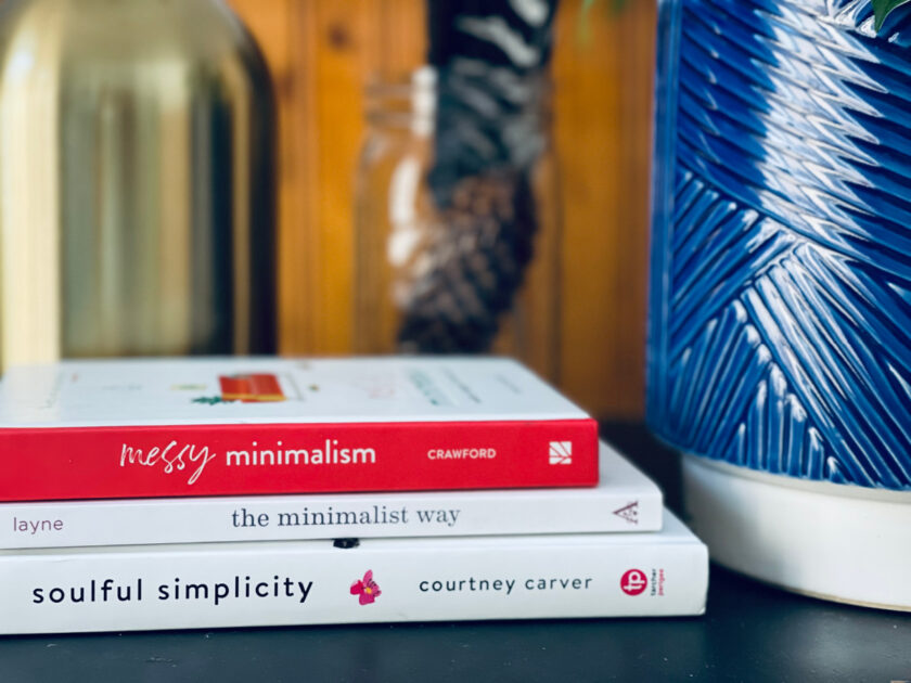 stack of books on minimalism sitting on table with blue planter in background