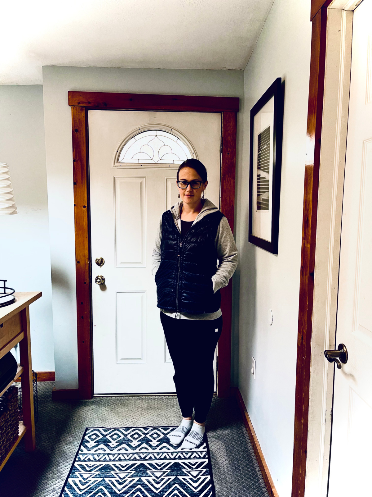 author standing by front door, modeling outfit from minimalist winter wardrobe
