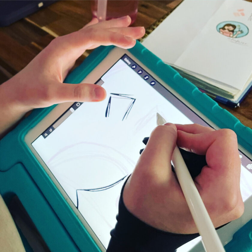 unschooled teen holding apple pencil, drawing on a tablet 