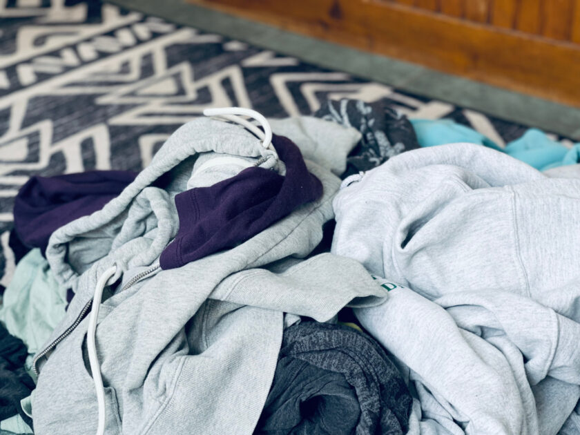 pile of clothes on floor, needing to be decluttered