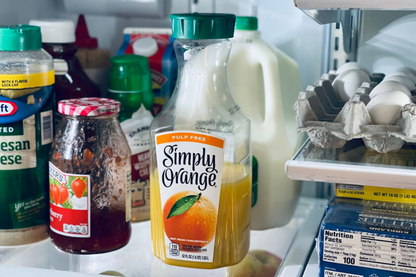 refrigerator shelves full of groceries, including orange juice, milk and strawberry jam