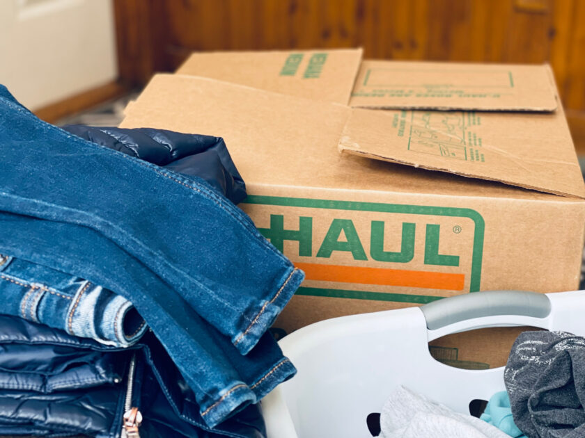 clothes, moving box and laundry basket close together, ready to declutter