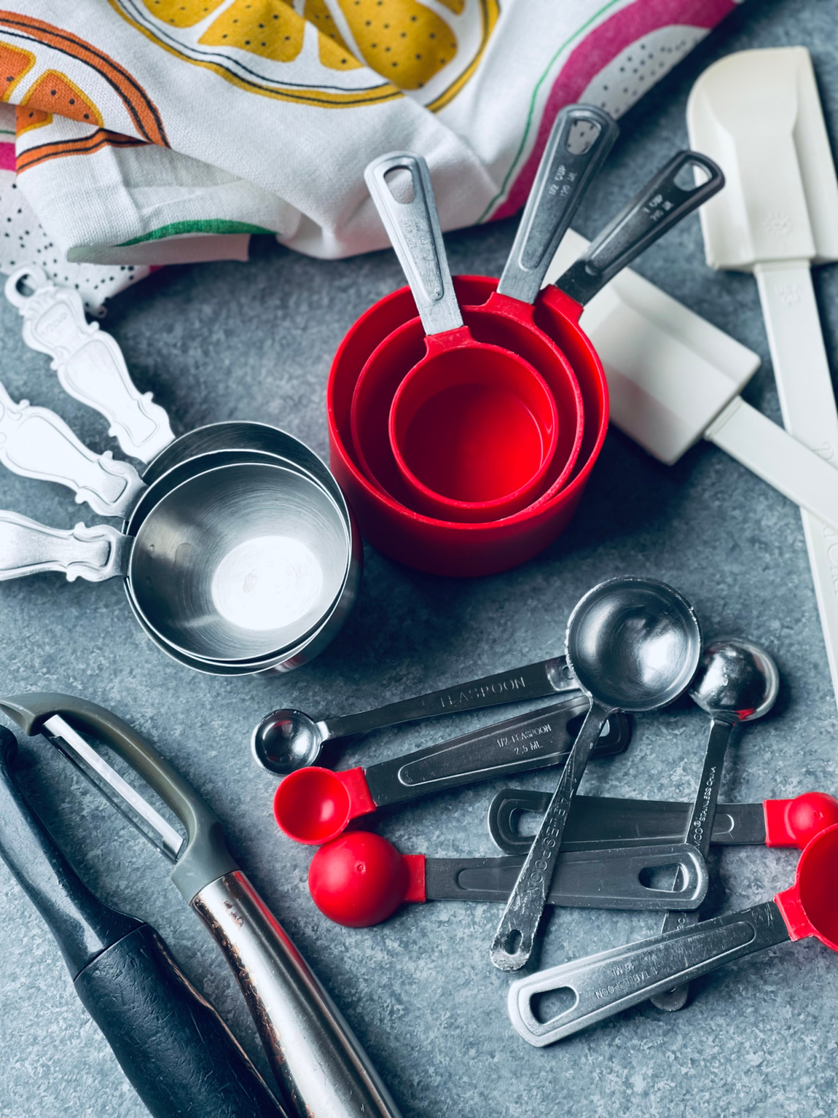 baking utensils and measuring cups and spoons spread out, duplicates of everything