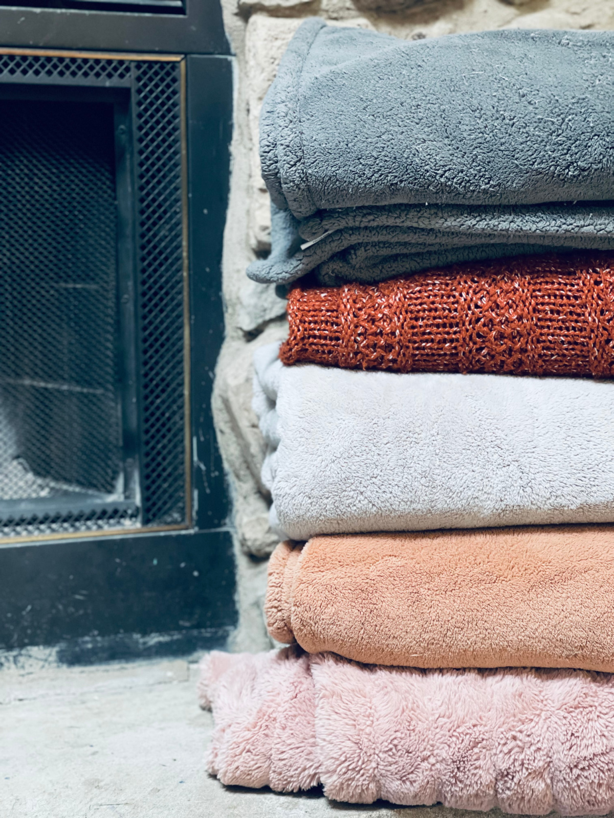 stack of throw blankets on fireplace