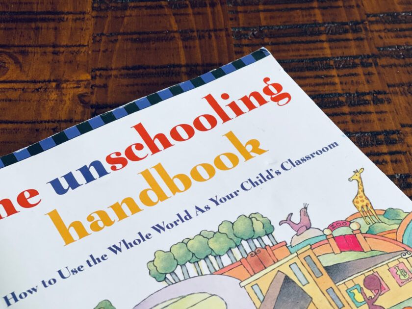 book "the unschooling handbook" sitting on coffee table