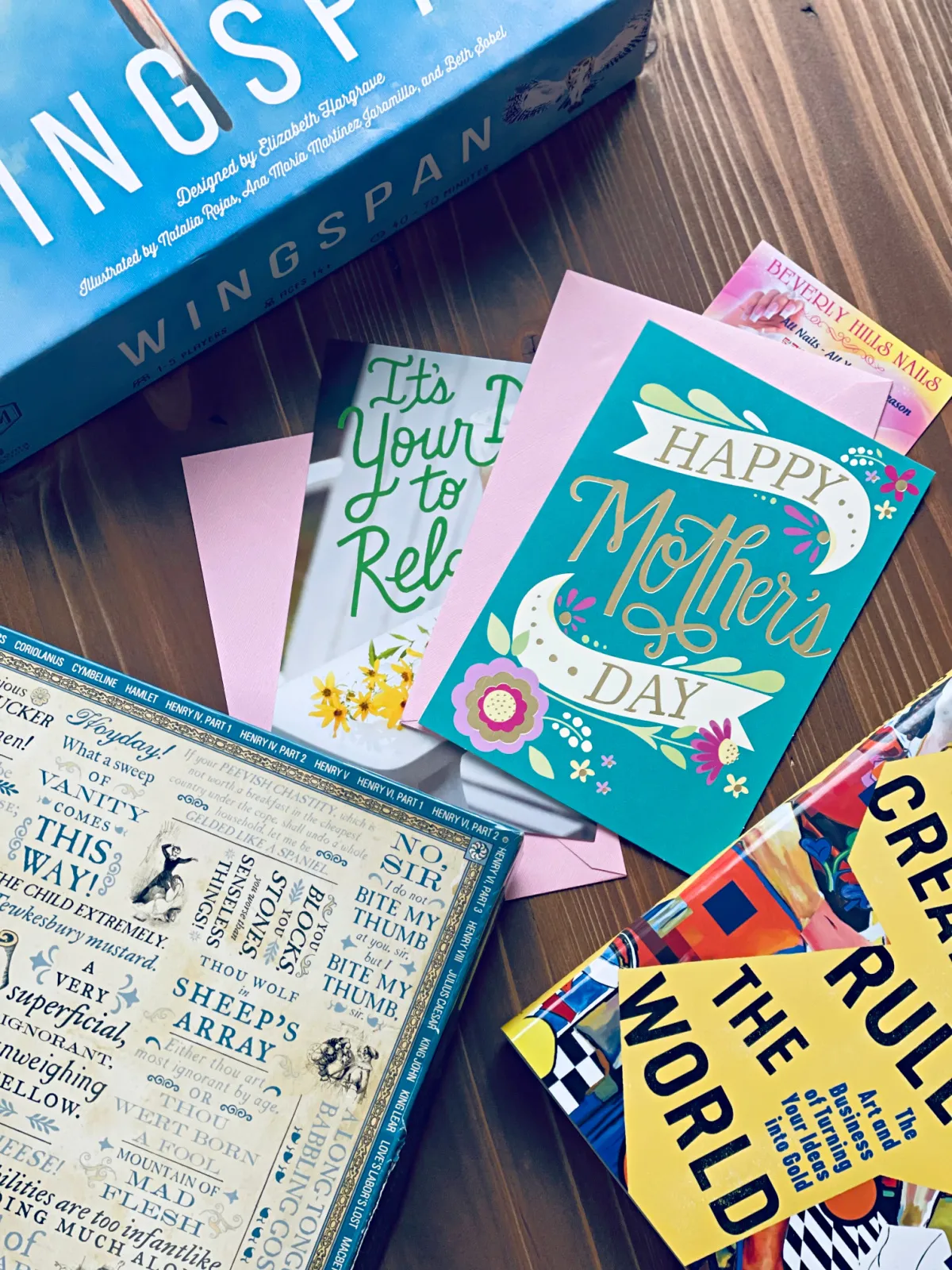 Wingspan board game, jigsaw puzzle, book and "Happy Mother's Day" cards spread out on table