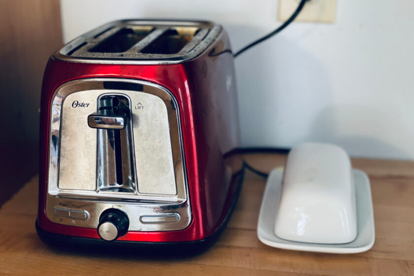 red toaster and white butter dish sitting on counter