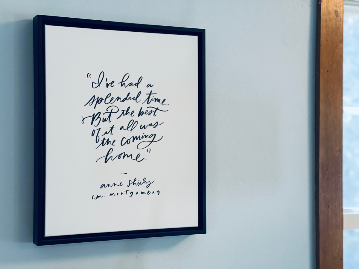 canvas art in minimalist home with quote "I've had a splendid time, but the best of it all was coming home" by Anne Shirley