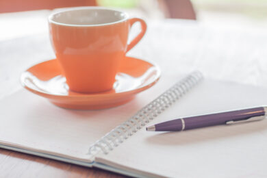 coffee cup and pen on notebook