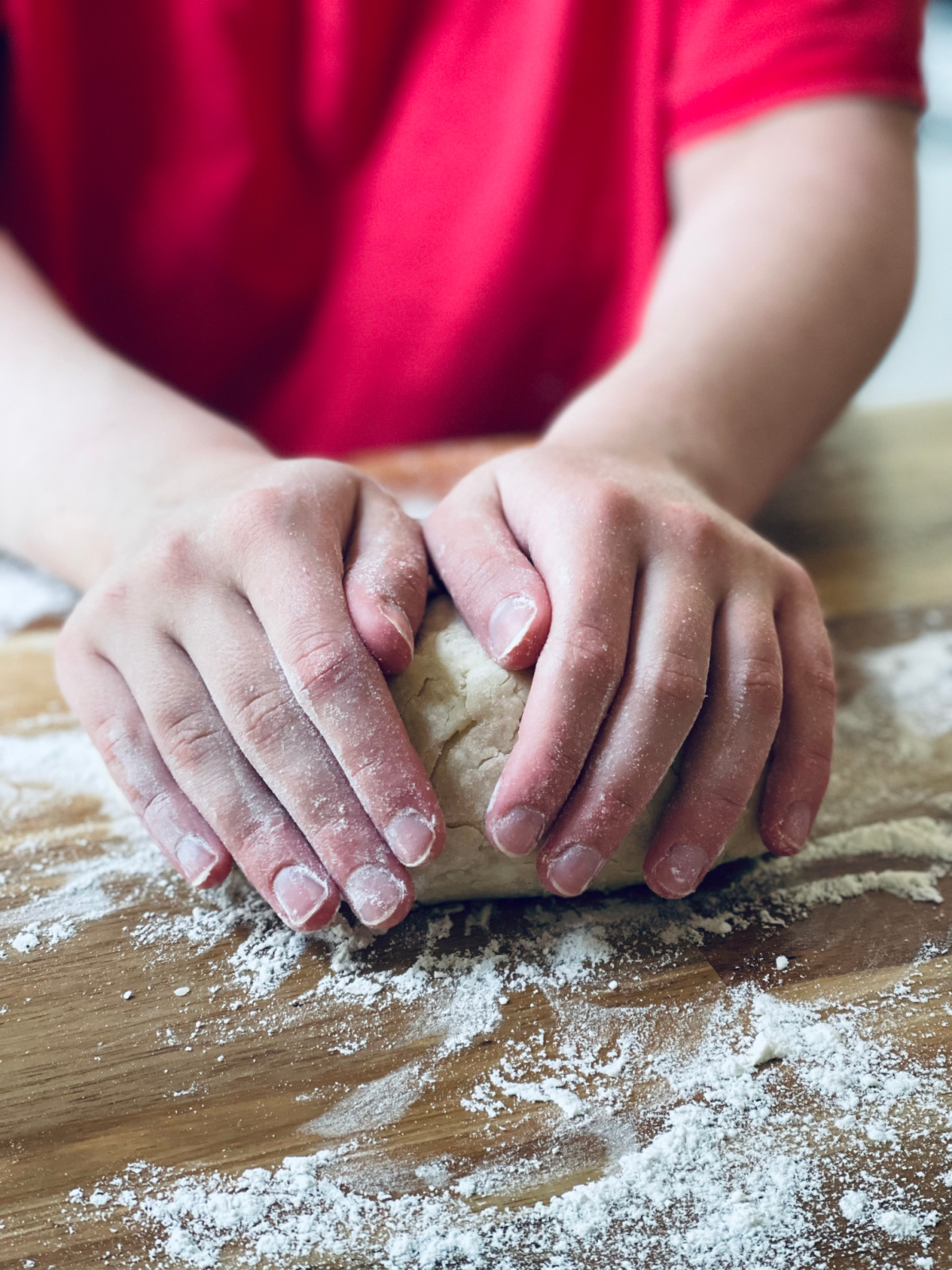 unschooled child's hands kneading pie dough.
