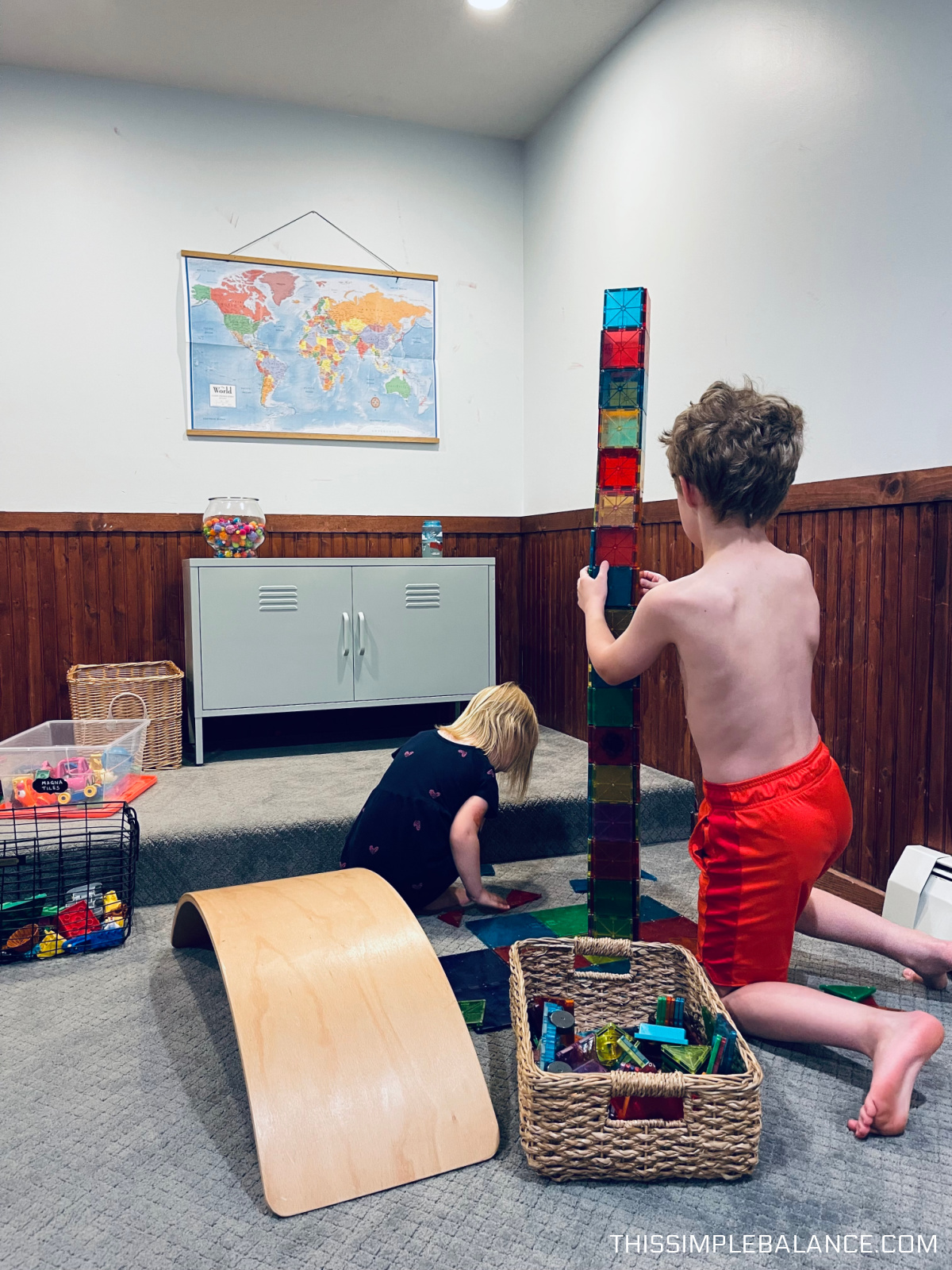 unschooling children building a magna tile tower to the ceiling together