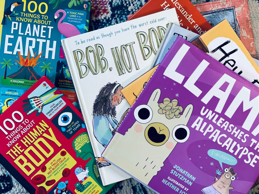 picture books for unschooling kindergarten stacked on carpet.