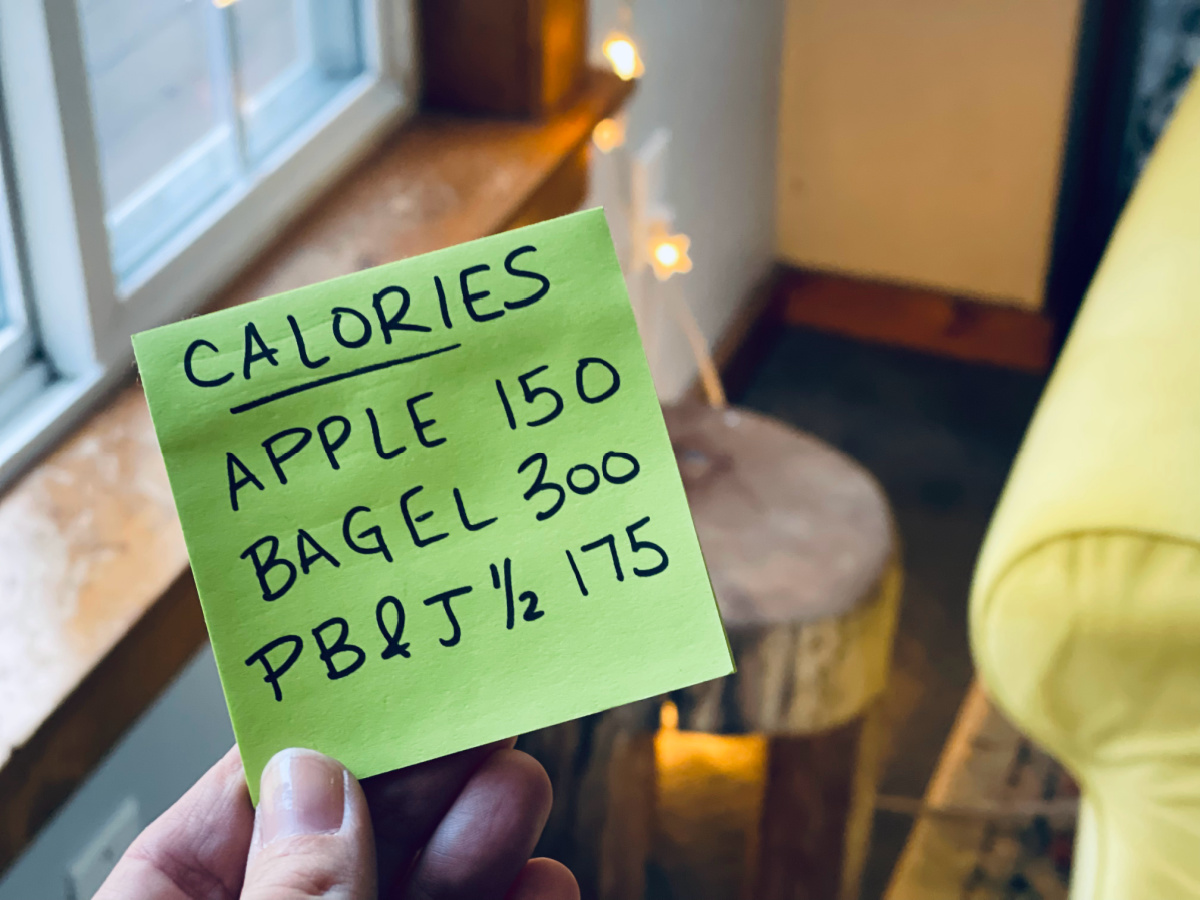 post-it note with calories with foods and calorie counts listed.