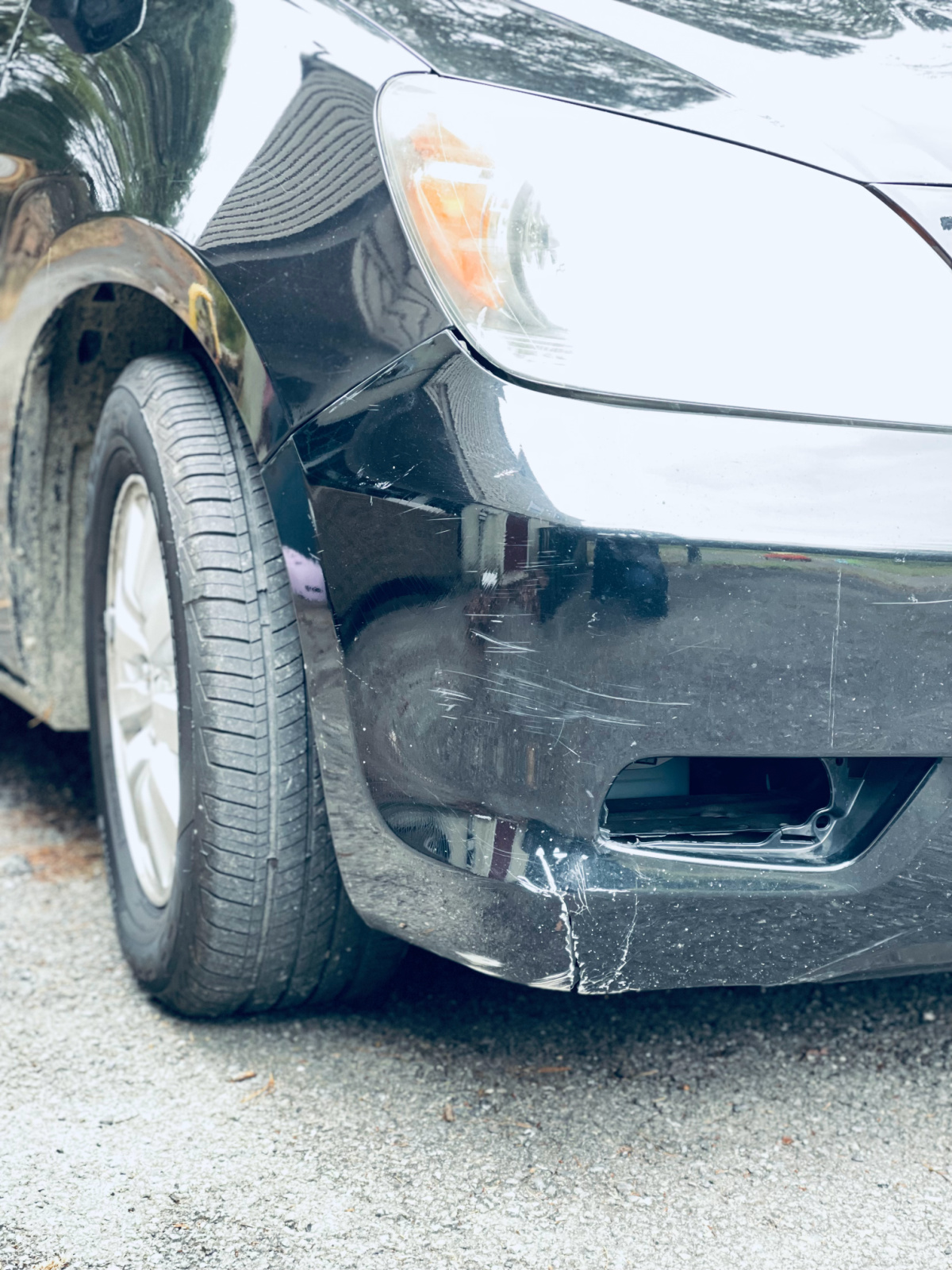 black 2009 honda odyssey front with small crack and missing piece.