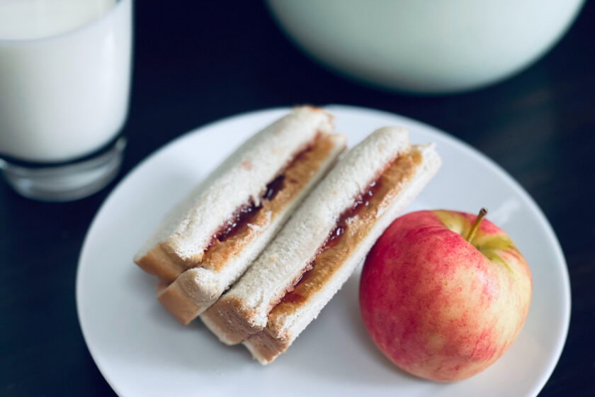 peanut butter and jelly sandwich with apple and milk