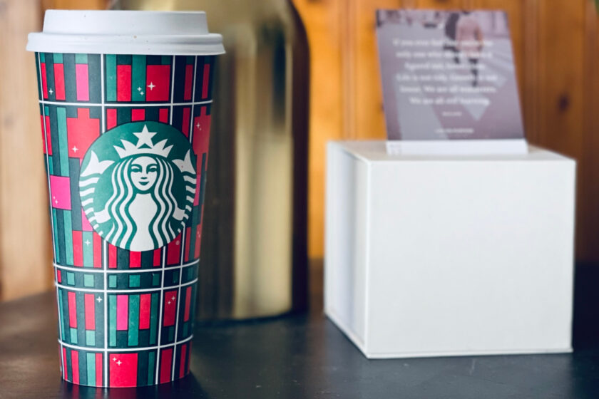 starbucks cup on table near lamp and calendar