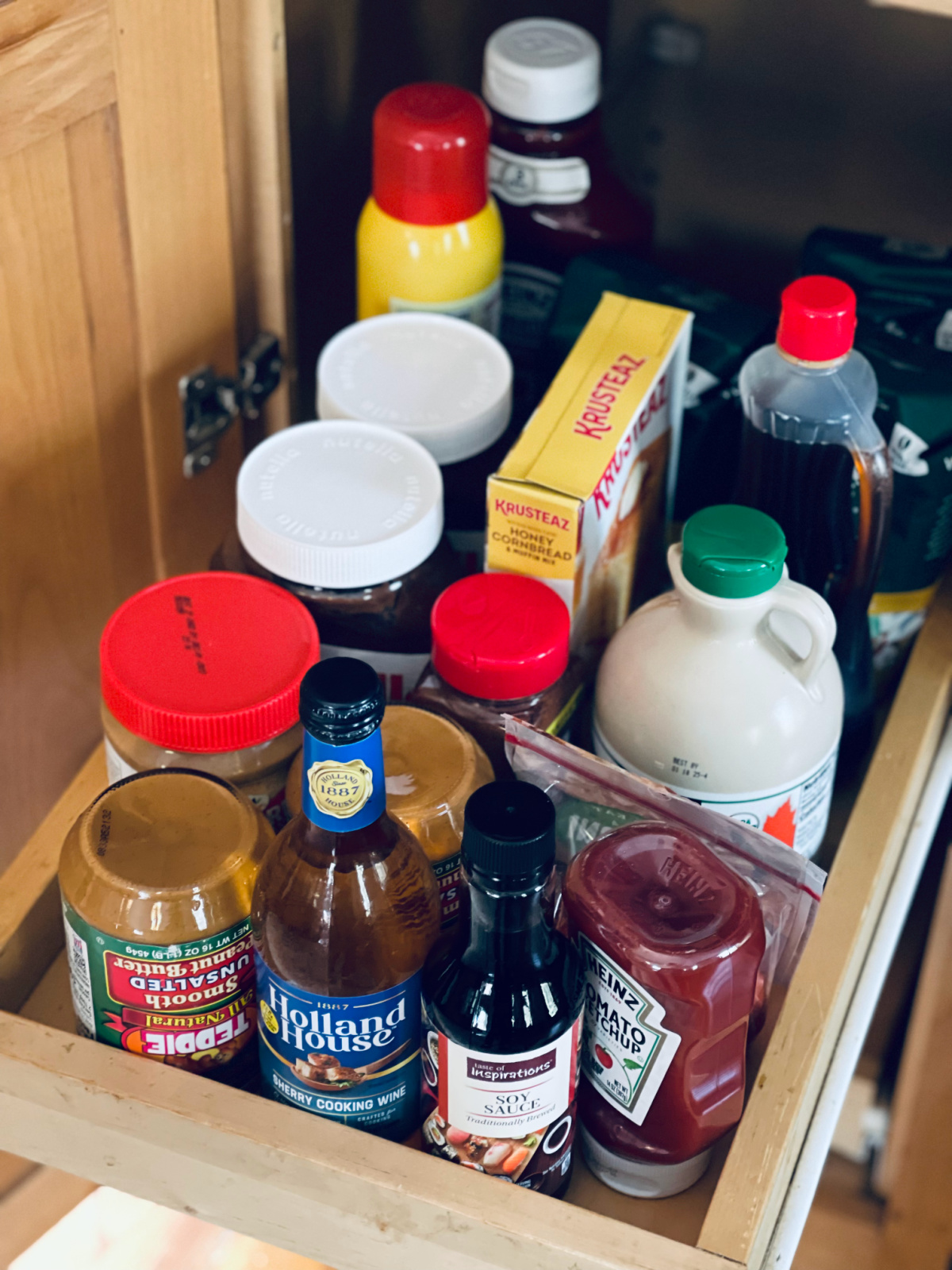 minimalist pantry shelf with extra condiments, oils, syrups and other staples