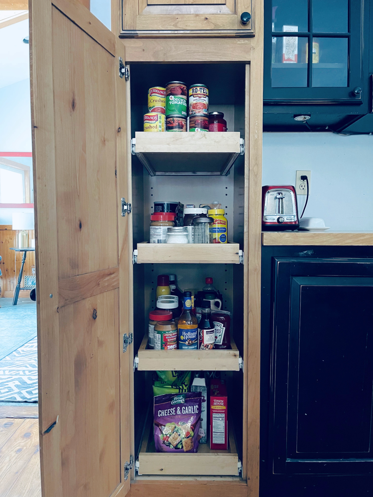 minimalist pantry pull-out shelves with canned goods, condiments, spreads, and snacks.