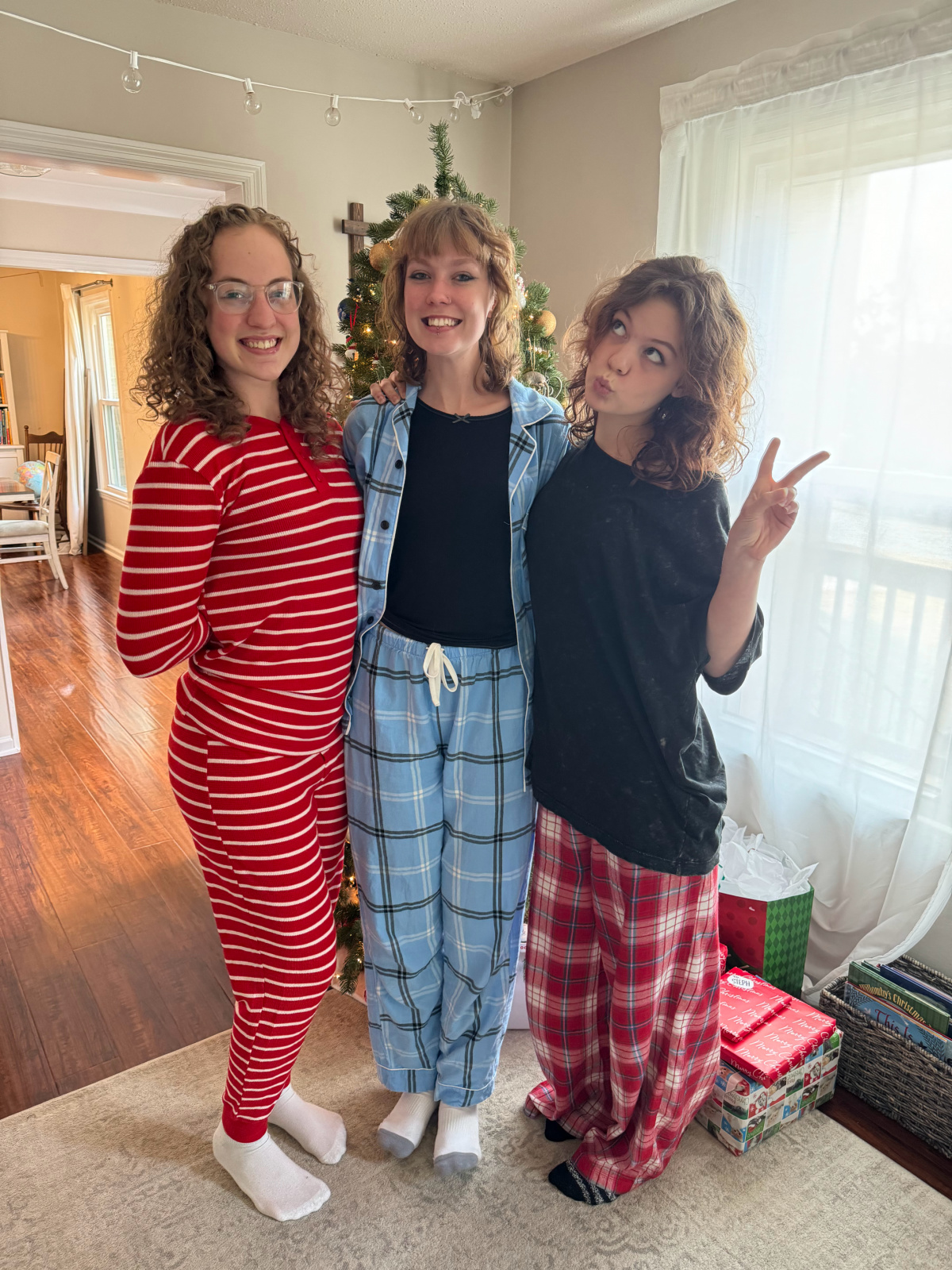Taviano sisters, Christmas morning picture in front of Christmas tree.